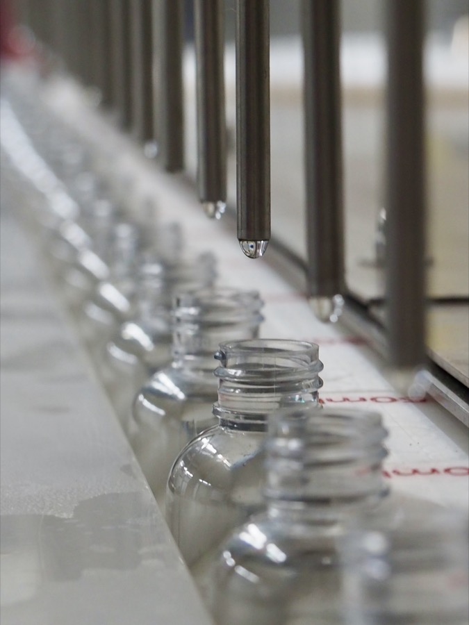 2oz bottles moving down the shot line before filling